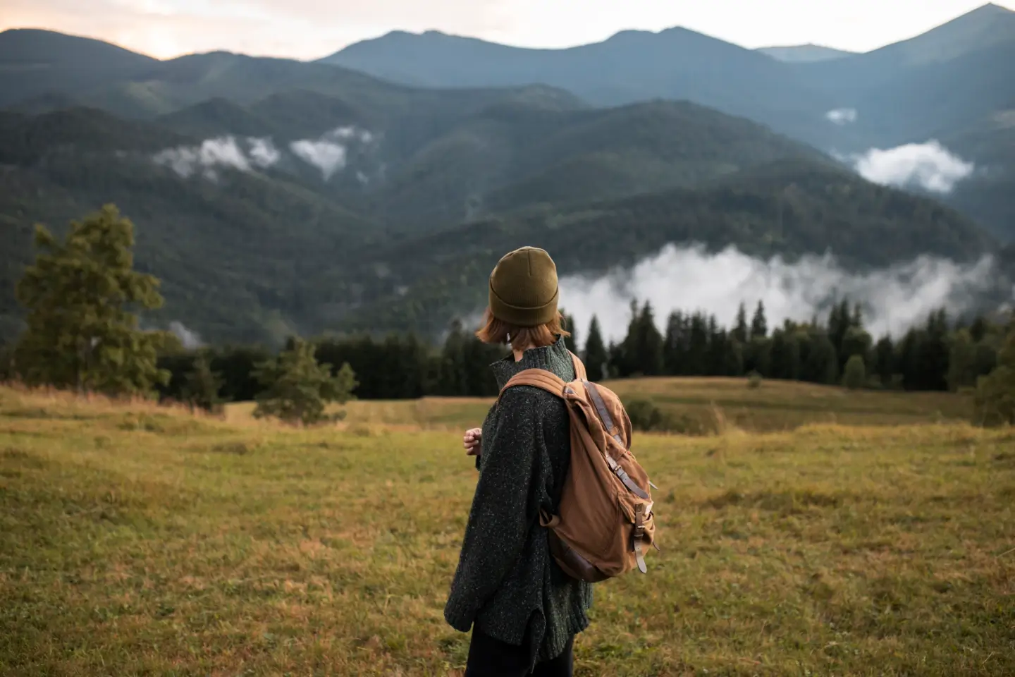 Hiker looking over misty mountains at dusk